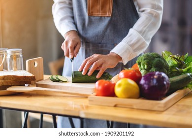 Closeup Image Of A Female Chef Cutting And Chopping Vegetables By Knife On Wooden Board In Kitchen