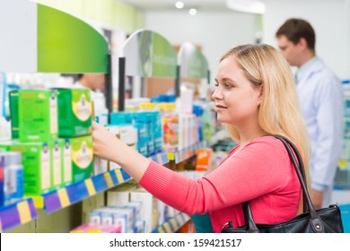 Close-up Image Of A Female Customer Doing The Shopping In The Drugstore On The Foreground