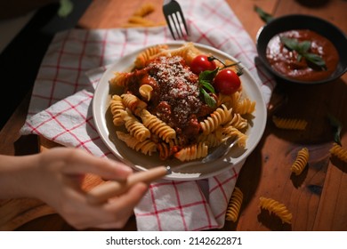 Close-up Image, Female Eating Fusilli Pasta With Fork And Spoon. Traditional Italian Food Concept.