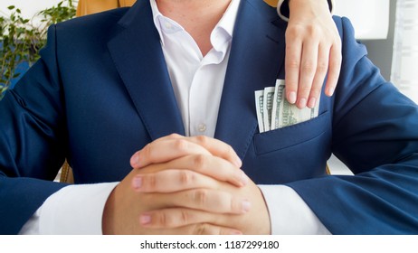 Closeup Image Of Female Hand Stealing Money From Businessman's Pocket