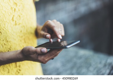 Close-up image of female hands typing on touch screen of modern smartphone, young hipster girl sending an sms message via cellphone, social networking concept, film effects