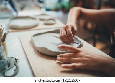 Closeup Image of Female Hands Works with Clay Makes Future Ceramic Plate, Professional Ceramic Artist Makes Classes of Hand Building in Modern Pottery Workshop, Creative People Handcrafted Design - Powered by Shutterstock