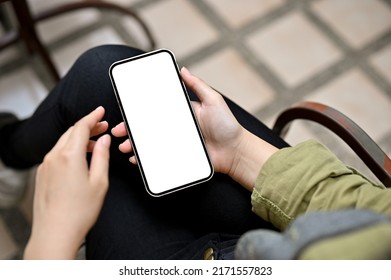 Close-up Image, A Female Relaxes In The Garden Using Smartphone, Scrolling On Social Media, Or Texting With Someone. Phone White Screen Mockup.