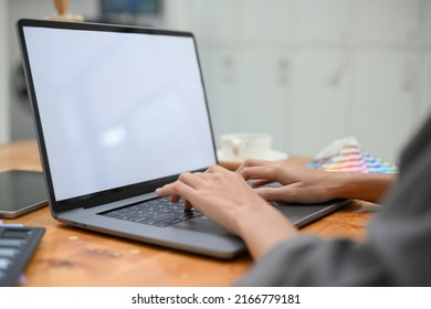 Close-up image, A female using portable laptop computer, typing on notebook keyboard, browsing internet. laptop white screen mockup
