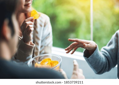 Closeup Image Of Friends Eating And Sharing Potato Chips Together