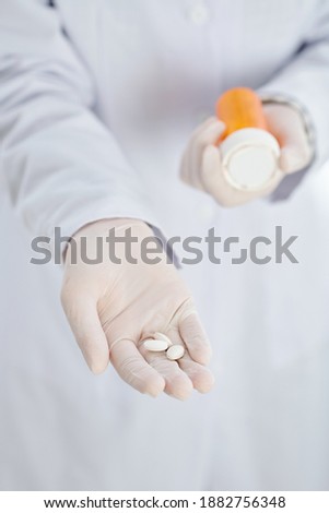 Close-up image of general practitioner in latex gloves giving pills to patient, selective focus
