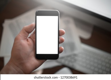 Close-up image of hand holding smartphone with blank mockup on paper background. - Shutterstock ID 1270038691