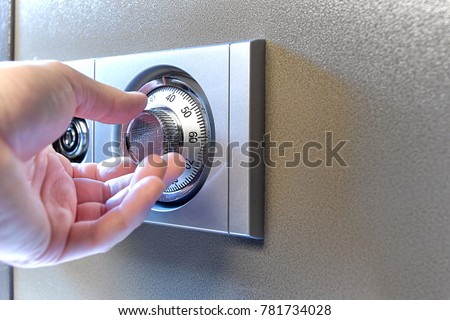 Closeup image of a hand opens a mechanical lock of a safe. High resolution studio image. Item is safe and combination.