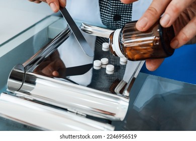 Closeup image hand of pharmacist counting and arrange pills on qualified stainless counting tray with spatula in pharmacy. Pharmacist prepare medication in stainless tray by prescription at drugstore. - Powered by Shutterstock