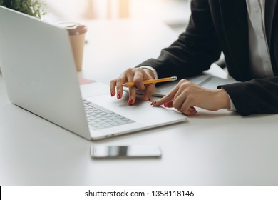 Closeup image of hand using and touching on laptop touchpad on table. Working in modern office.