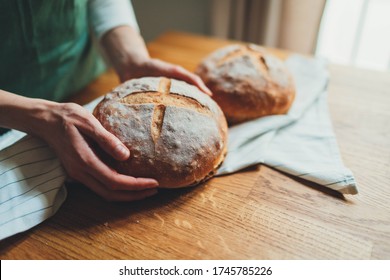 Closeup Image Of Woman’s Hands Holding Homemade Sourdough Bread, Craft Authentic Bread And Home Cooking Concept. Food Preparation