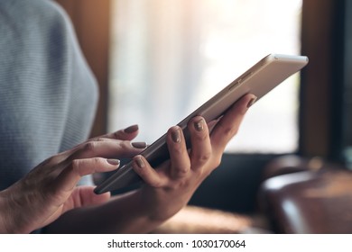 Closeup image of hands holding and using tablet pc in cafe - Shutterstock ID 1030170064