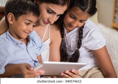 Close-up Image Of Indian Family Gathered At Digital Tablet