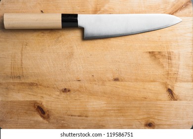 Closeup image of kitchen japanese style chef knife on vintage cutting board