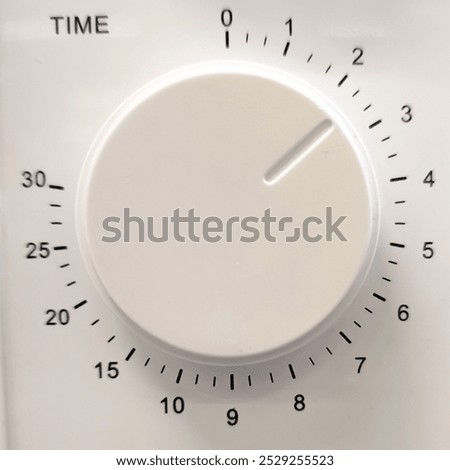 A close-up image of a kitchen timer dial, showcasing the time settings from 0 to 30 minutes. The white circular dial features clear markings and a simple design, ideal for cooking and baking. This ima