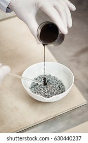 Closeup Image Of Liquid Bitumen Sample Being Poured, White Rubber Gloves. On Road Laboratory- Testing Facility 