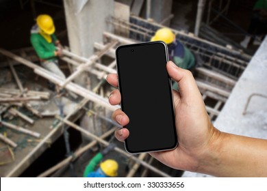 Closeup image with male hand hold and touch screen smart phone, tablet,cellphone over blurred Construction site background. - Powered by Shutterstock