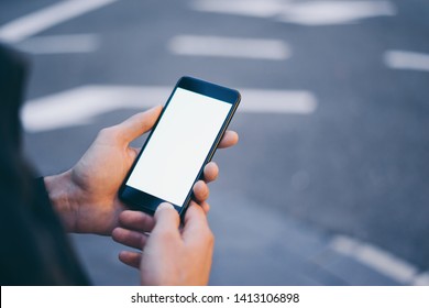 Closeup image of male hand holding modern smartphone with blank screen. Mockup ready for text message or content. Man's hands with cellphone. Empty display. Night street, bokeh light - Shutterstock ID 1413106898