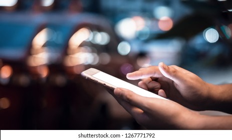 Close-up image of male hands using smartphone at night on city shopping street, searching or social networks concept, hipster man typing an sms message to his friends - Powered by Shutterstock