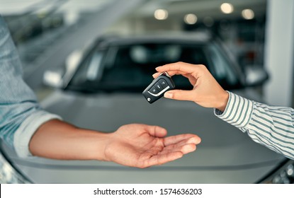 Close-up image a man buys a car and receives keys from the seller. - Shutterstock ID 1574636203