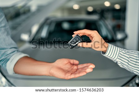 Close-up image a man buys a car and receives keys from the seller.