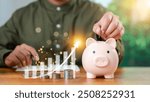 Close-up image of man hand putting coins in pink piggy bank for account save money. saving money wealth and financial concept, Business, investment, Financial planning. saving money for future plan.