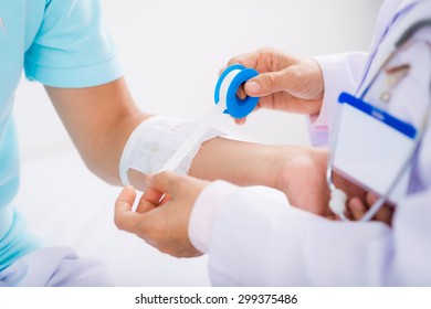 Close-up image of man having arm bandaging