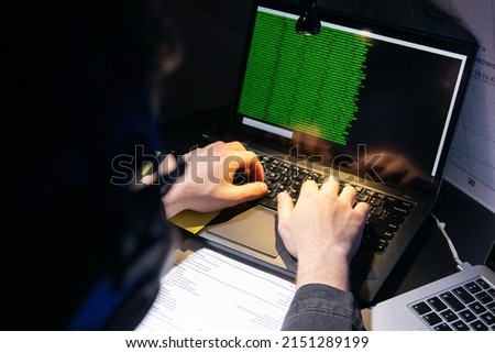 Close-up image of man planning hacker attack. Man using laptop, typing code. Male hands on keyboard. Hacking, technology, cybercrime concept