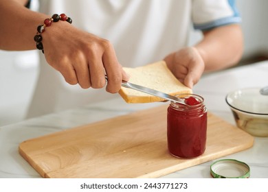 Closeup image of man spreading jam on piece of bread - Powered by Shutterstock