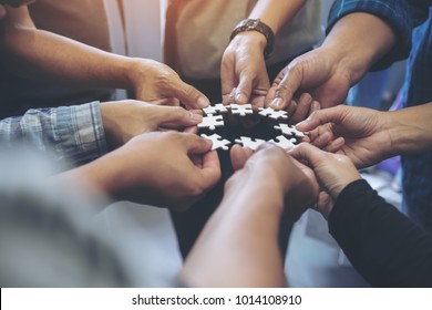 Closeup Image Of Many People Hands Holding A Jigsaw Puzzle In Circle Together