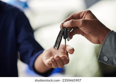 Closeup image of mechanic giving car keys to client after repairing it - Powered by Shutterstock