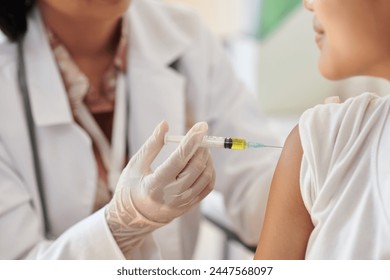 Closeup image of medical worker injecting vaccine in arm of patient - Powered by Shutterstock