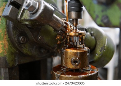 Close-up image of a metal drilling machine in action with lubricant oil flowing. Ideal for illustrating industrial machining, manufacturing processes, and engineering concepts. - Powered by Shutterstock