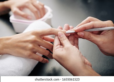 Close-up Image Of Nail Master Pushing Cuticle With Metal Manicure Tool
