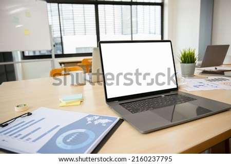 Closeup image, Notebook laptop computer blank screen mockup and business paperwork on meeting table.