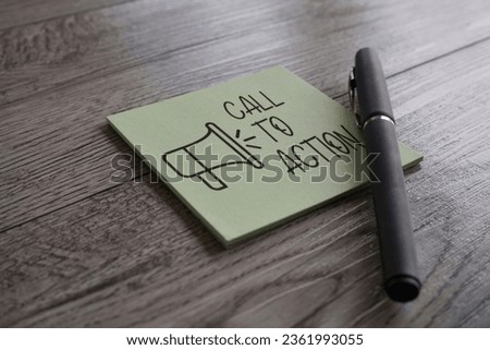 Closeup image of notepad with text CALL TO ACTION and pen on table. Business concept
