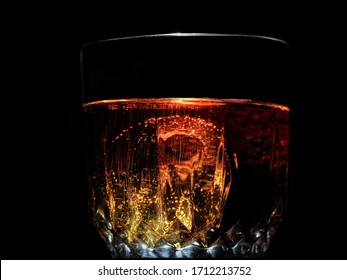 Closeup Image Of Pepsi Pores Into A Crystal Glass Cup With A Large Piece Of Ice Cube And Bubbles