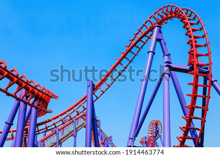 close-up image of a rollercoaster track and the blue sky
