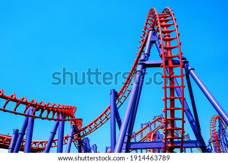 close-up image of a rollercoaster track and the blue sky
