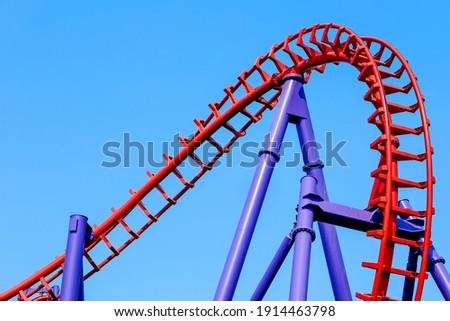 close-up image of a rollercoaster track and the blue sky