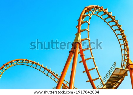 close-up image of a rollercoaster track and the blue sky