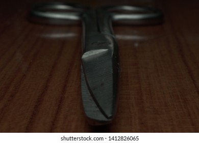 close-up image of scissors in low-light condition with blurred on the handle. 