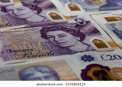 A closeup image of several British twentypound banknotes featuring Queen Elizabeth IIs portrait and a detail of the Twenty Pounds text. - Powered by Shutterstock