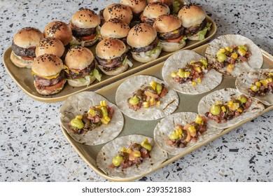 A close-up image showcases an array of delectable mini burgers and rotis, artfully arranged on platters, promising a culinary journey in mini form - Powered by Shutterstock