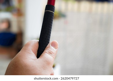 Close-up image showing a simple one-handed golf club grip technique.