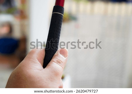 Close-up image showing a simple one-handed golf club grip technique.