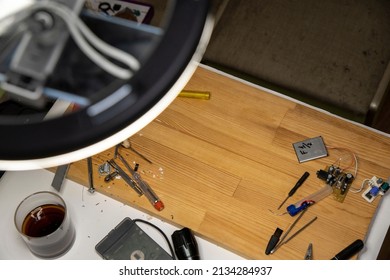 Closeup image of simple electric circuit, breadboard with electrical components, diode, resistors, soldering electrical colored cables and wires. Hand soldering station. Electronic parts
