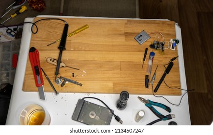 Closeup image of simple electric circuit, breadboard with electrical components, diode, resistors, soldering electrical colored cables and wires. Hand soldering station. Electronic parts