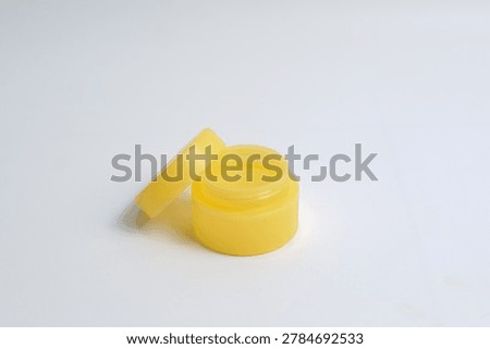 Close-up image of a small blue plastic cosmetic container on a white background.