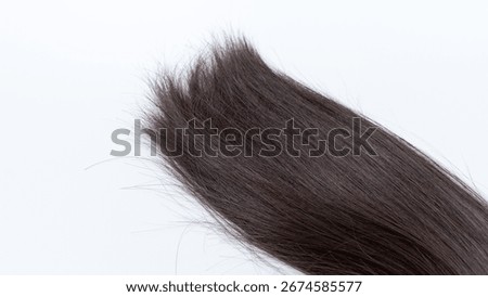 Close-up image of split ends on dark brown hair, highlighting the texture and condition, conveying themes of hair health and beauty care